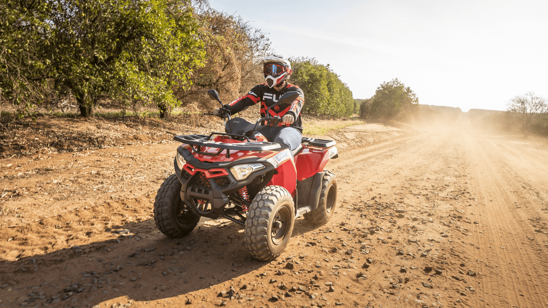 A person riding a red quad bike