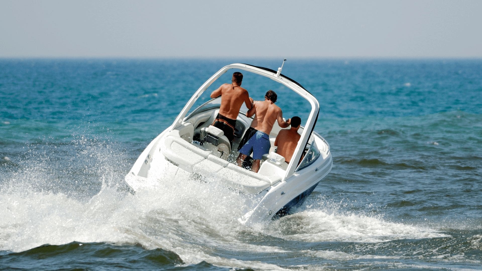 En vit båt med 3 män ombord
