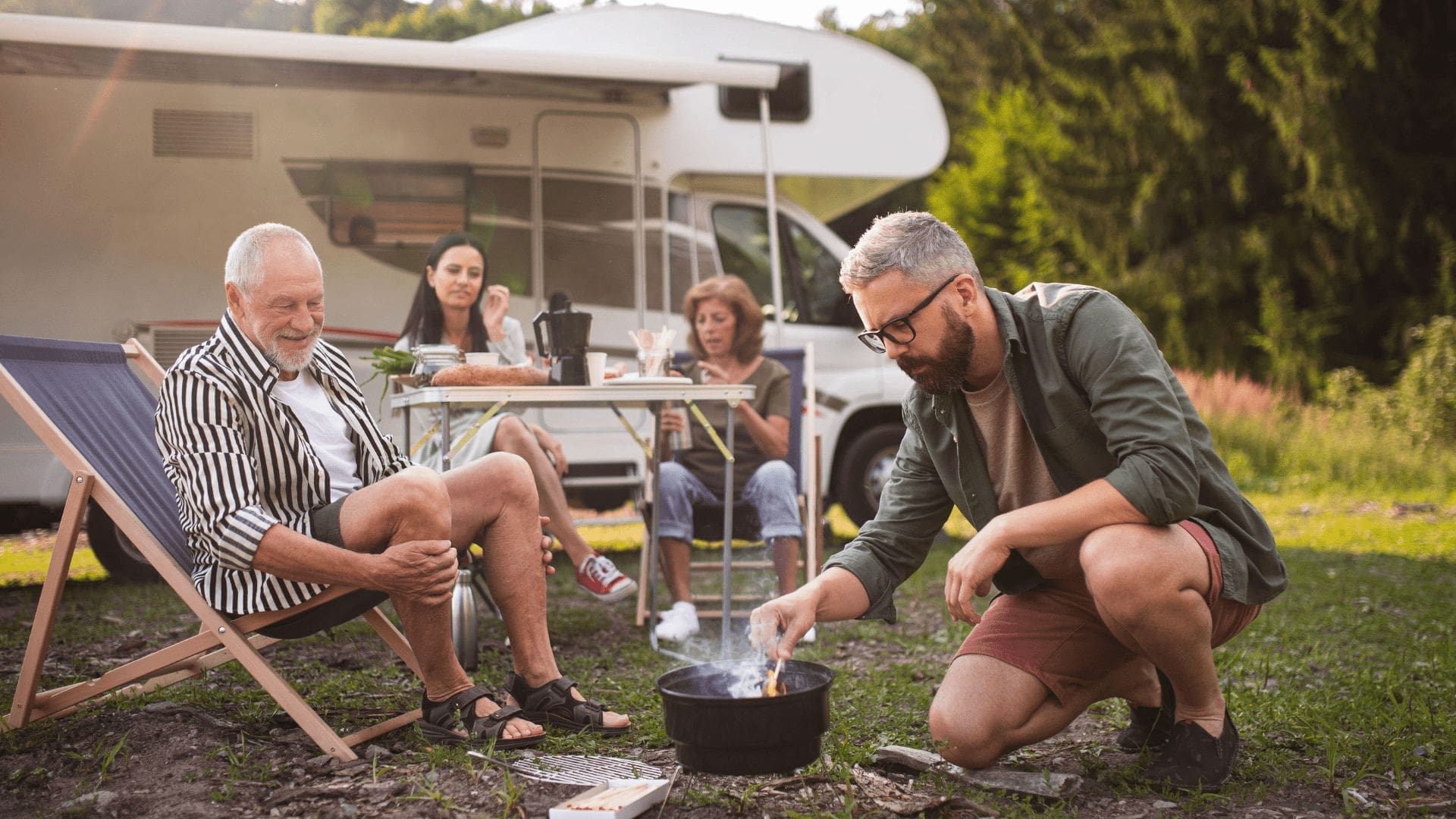 Ett gäng framför en husbil som grillar