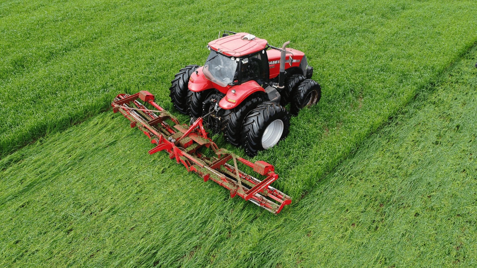 En röd traktor som tröskar