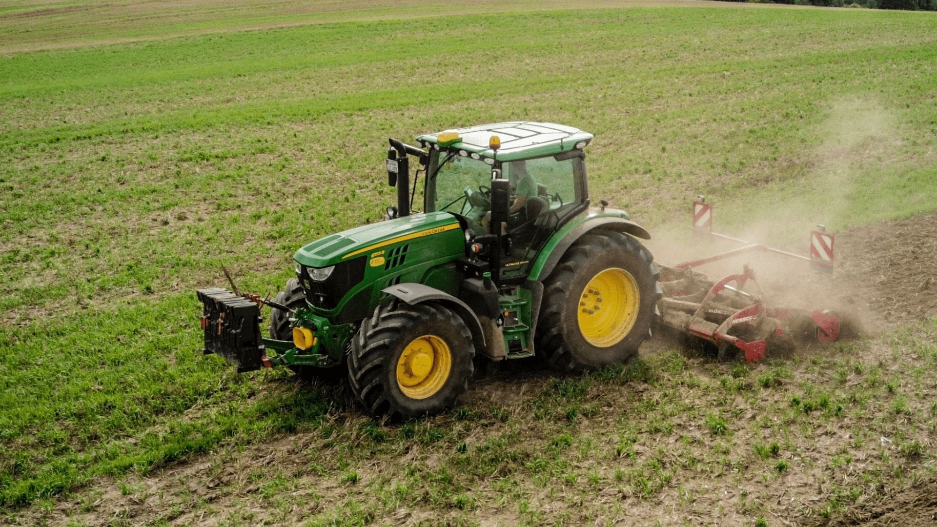 En grön traktor som tröskar